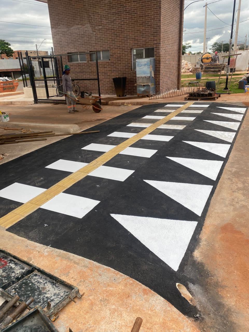 Faixa elevada de pedestres pintada em branco com triângulos nas rampas