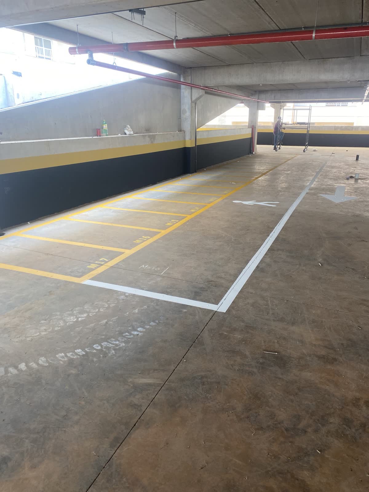 Estacionamento coberto com vagas demarcadas em amarelo e branco