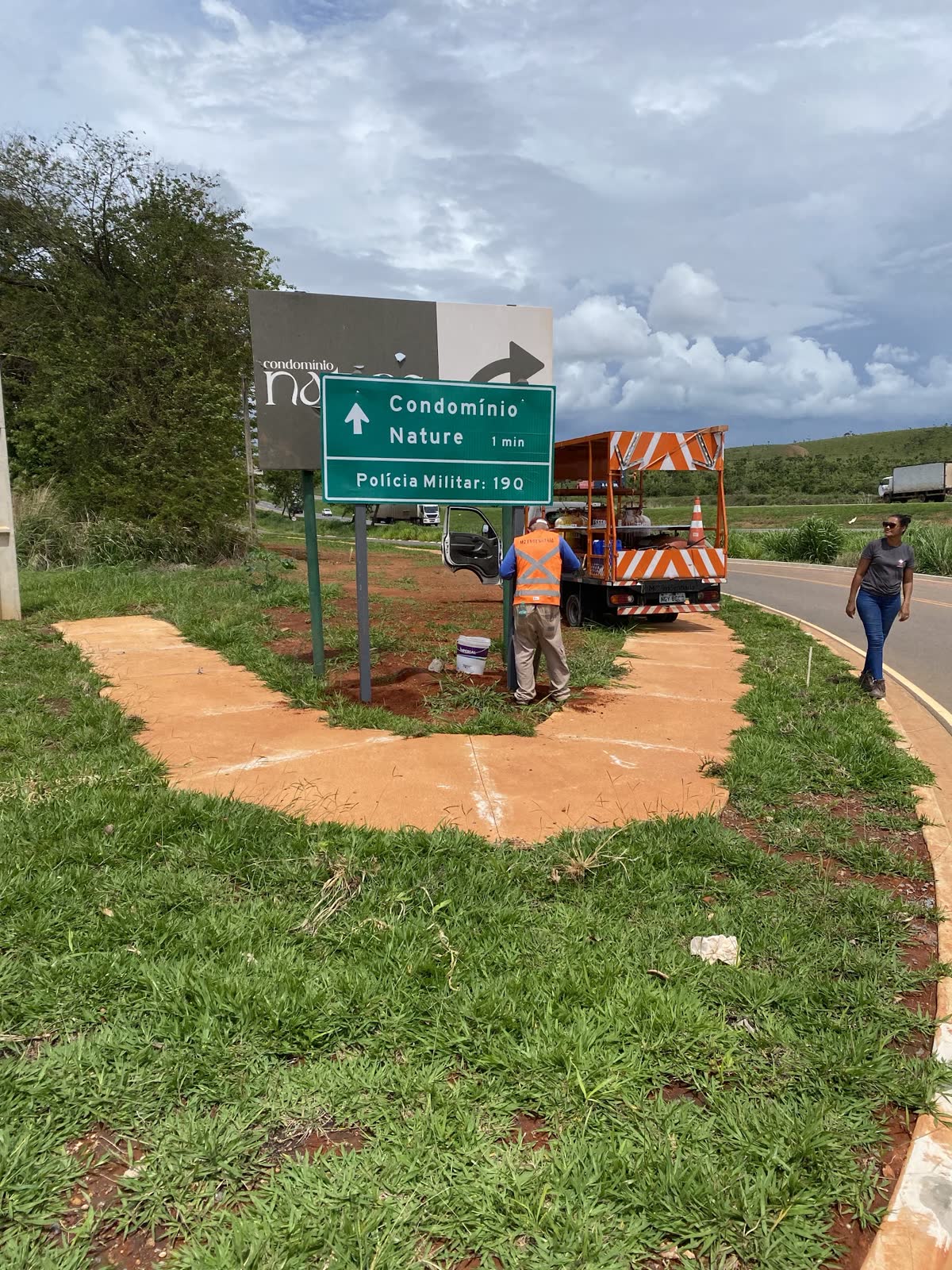 Equipe instalando placa de indicação de destino em loteamento