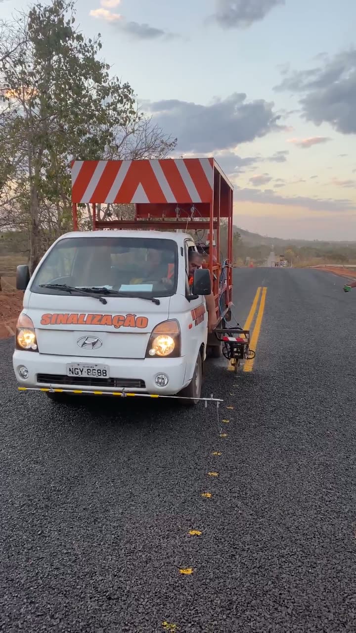 Veículo de sinalização da MZ Engenharia pintando a linha dupla amarela de uma rodovia